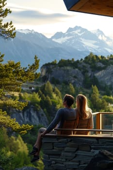 Couple sitting on a balcony with a mountain view, sharing a moment of connection at dusk