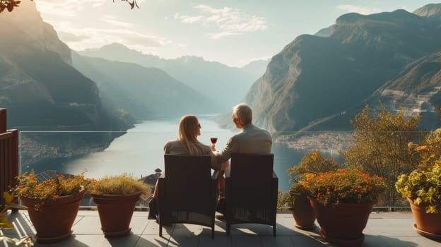 Couple enjoying a glass of wine on a balcony overlooking a serene mountain lake at sunset