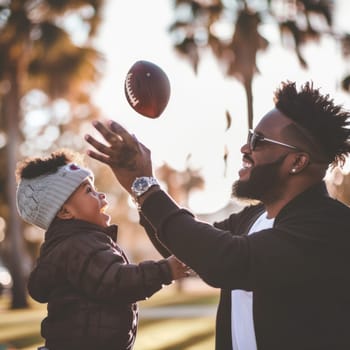 Father and son sharing a joyous moment playing football on a sunny day