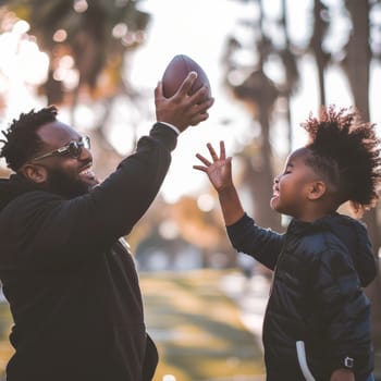 Father and son sharing a joyous moment playing football on a sunny day