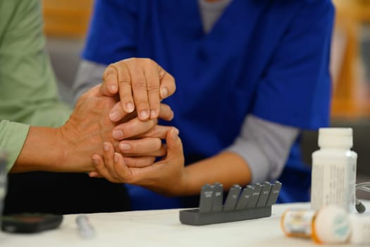 Caring nurse holding hands comforting upset senior patient. Elderly healthcare concept.