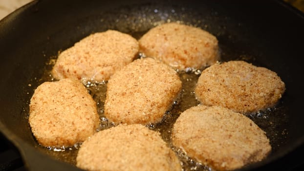 Fried cutlets in a frying pan with sunflower oil. Rustic menu. Traditional rustic food. Close-up. Homemade hamburger cutlets.