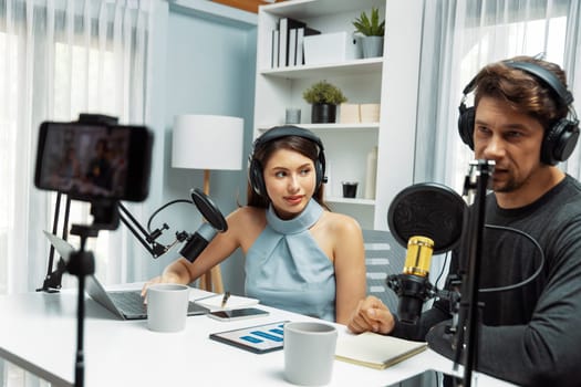 Host channel broadcasters discussing together, making advice for problem in live streaming with listeners surrounded sets of live streaming on radio talking show at comfy modern workplace. Postulate.