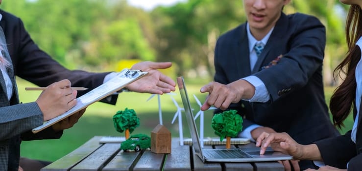 Group of asian business people presenting environmentally friendly development plan and sustainable technology project for greener future, establishing outdoor eco business office at natural park.Gyre