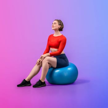 Full body length gaiety shot athletic and sporty young woman with fitness exercising ball in standing posture on isolated background. Healthy active and body care lifestyle.