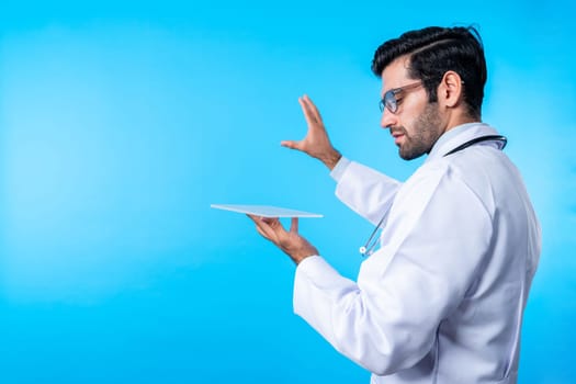 Back view of smart doctor looking application form while standing at blue background. Professional caucasian doctor diagnosis disease while looking at chart holding in hands. Close up. Deviation.