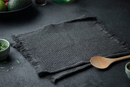 Empty space on the black stone table with wooden spoon for cooking on dark background . Horizontal