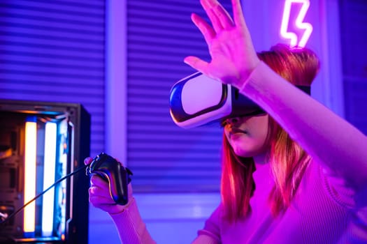 Excited woman playing watching video life simulation at home, Gamer in VR headset glasses exploring metaverse plays online video game touching something on air with neon lights, E-Sport metaverse