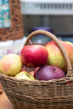 A natural foods ingredient, a wicker basket filled with apples of different colors is a staple food representing plantbased whole food. The wood storage basket showcases the variety of fruits