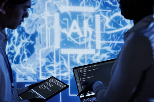 Hardworking colleagues write code on tablet and laptop to visualize artificial intelligence neural networks using augmented reality. Teamworking coworkers run AI script for information processing