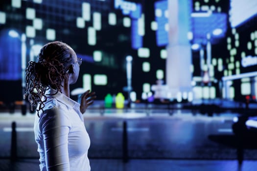 Woman wandering around city boulevards during nighttime, being amazed by urban landscape buildings. Citizen strolling around empty avenues at night, enjoying dimly illuminated surroundings