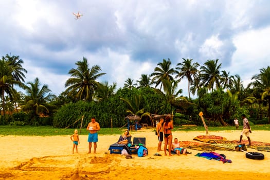 Beautiful beach with tropical nature sand water waves people fun parasols and sun loungers in Bentota Beach on Sri Lanka island.