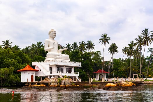 Large white Buddha statue in Bentota Udakotuwa Temple at Bentota Ganga in Bentota Beach Galle District Southern Province Sri Lanka.