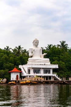 Large white Buddha statue in Bentota Udakotuwa Temple at Bentota Ganga in Bentota Beach Galle District Southern Province Sri Lanka.