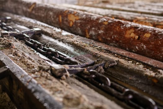 At sawmill. Image of wood and chain, close-up