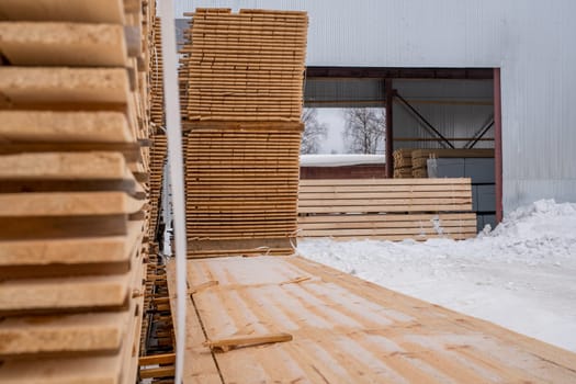 At sawmill. Image of boards stacked outside in winter time