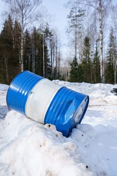 Image of blue striped barrel on snow in forest