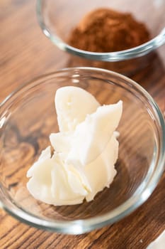 An array of ingredients is meticulously arranged on a wooden table, ready to transform into a delectable gingerbread bundt cake adorned with caramel frosting.