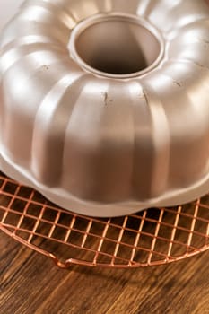 The gingerbread bundt cake cools gracefully on a wire rack, awaiting its sweet caramel frosting.