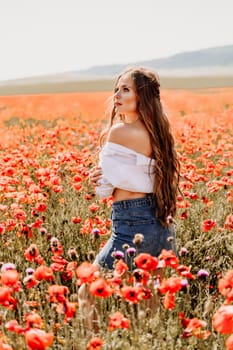 Woman poppies field. Side view of a happy woman with long hair in a poppy field and enjoying the beauty of nature in a warm summer day