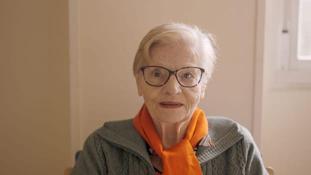 Senior woman looking at camera sitting on a nursing home