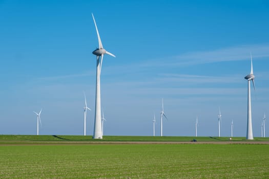 A scenic view of a vast field of green grass with numerous windmills spinning gracefully in the background, creating a picturesque landscape.