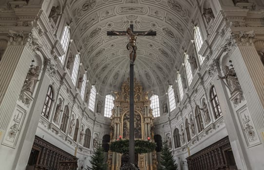 Munich, Germany - Dec 21, 2023 - Jesus hanging on the cross, Crucifix in the interior of St. Michael's Church (Michaelskirche Jesuit church) in Munich pedestrian zone. It is the largest Renaissance church north of the Alps. Space for text, Selective focus.