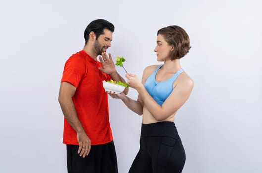 Full body length gaiety shot athletic and sporty young couple with healthy vegan food in standing posture on isolated background. Healthy active and body care by vegetarian lifestyle.