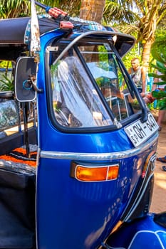 Bentota Beach Southern Province Sri Lanka 16. March 2018 Driving a blue Rickshaw Tuk Tuk cab vehicle in Bentota Beach Galle District Southern Province Sri Lanka.