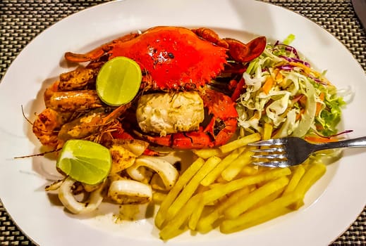 Lobster Shrimps Crabs Squid Seafood on plate in the hand in Bentota Beach Galle District Southern Province Sri Lanka.