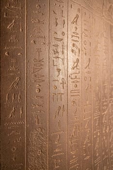 Egyptian hieroglyphs on a stone in a tomb close-up. photo