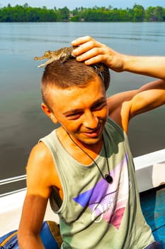 Man tourist with baby crocodile alligator in his hands at Bantota Ganga river in Bentota Beach Galle District Southern Province Sri Lanka.