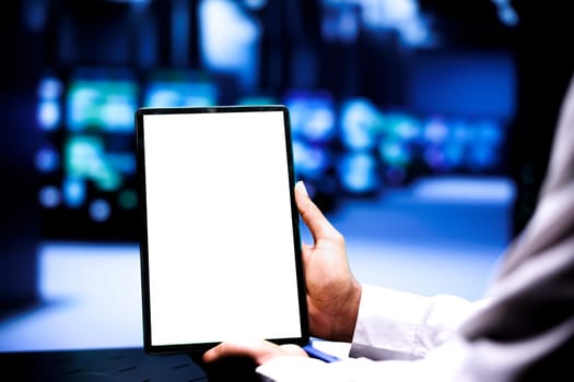 Serviceman using mock up tablet to do checkup on servers helping businesses host websites and store files. Worker inspecting supercomputers used for high performance computing, close up