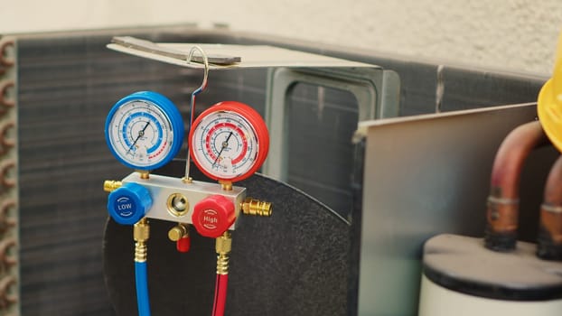 Dolly in close up shot of faulty pressure measurement device used for checking air conditioner refrigerant tank in need of fixing. Set of manifold indicators showing high or low freon levels