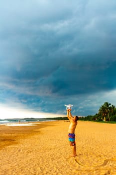 Man with drone on beautiful beach with tropical nature sand water waves people fun in Bentota Beach on Sri Lanka island.