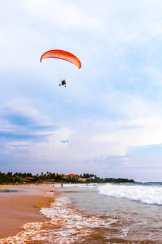 Beautiful beach with tropical nature sand water waves people fun parasols and sun loungers in Bentota Beach on Sri Lanka island.