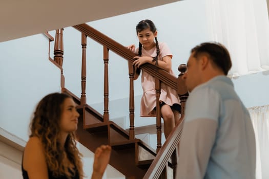 Stressed and unhappy young girl watch her parent arguing from the stair. Domestic violence at home and traumatic childhood develop to depression and anxiety. Unhealthy family concept. Synchronos