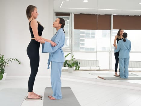 Caucasian woman stands on sadhu boards with therapist support