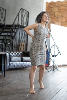 young beautiful woman posing in a short dress in the studio