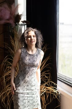 young beautiful woman posing in a short dress in the studio