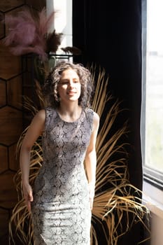 young beautiful woman posing in a short dress in the studio