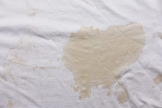spilled coffee on white shirt closeup ,