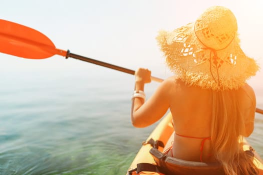 woman straw hat paddling a kayak on a lake. The sun is shining brightly, creating a warm and inviting atmosphere