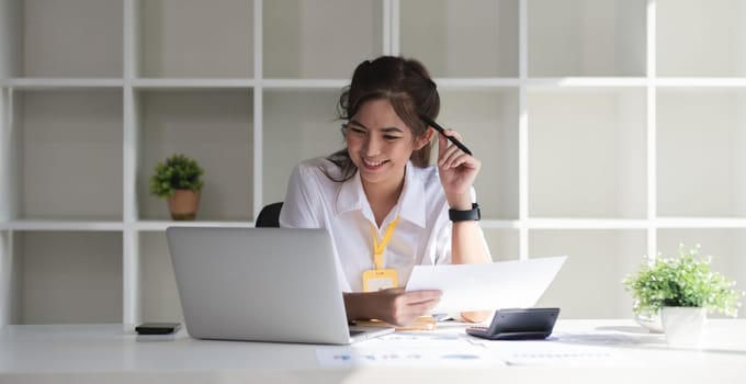 Business woman using calculator for do math finance on wooden desk in office and business working background, tax, accounting, statistics and analytic research concept..