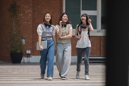 Group of happy students walking along the corridor at college.