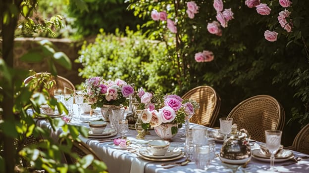 Table setting with rose flowers and candles for an event party or wedding reception in the summer garden.