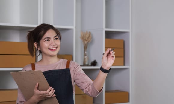 Female online business owner checks stock of products waiting to be delivered to customers. A talented SME business owner..