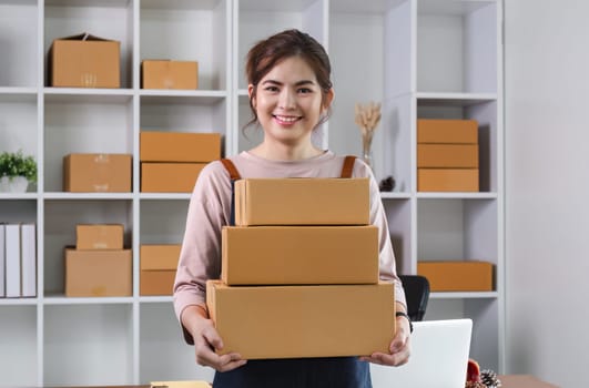 SME business owner holds a parcel box showing delivery of goods for an online business..