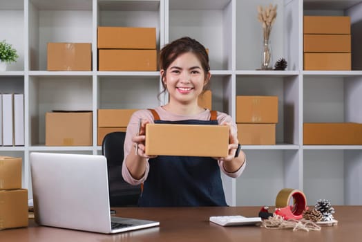 SME business owner holds a parcel box showing delivery of goods for an online business..