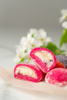 Multi-colored Japanese cakes Mochi in a white plate close up